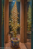<center>La fleur psychédélique</center>Or jaune à 18 carats; Dans la plante: Des pierres suspendues (92), taille mixte (ovale et ronde), de 8.0 à 11.0 mm, approximativement.; Pierres bleues:Saphir naturel (corindon), Spinelle naturelle, Aigue-marine (béryl); Pierres jaunes:Zircon; Pierres roses: Spinelle natural, Grenat; Pierres rouges:Spinelle naturelle, Grenat; Sur le pot à fleurs:Spinelles naturels (et quelque rubis), cristaux bruts; Lapis-lazuli, plaques polies; Avec un mécanisme à moteur avec réducteur qui fait pivoter la plante.