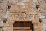<center>Saint-Genis des Fontaines.</center>Tout comme à Saint-André, la pierre sculptée placée au-dessus de la porte d'entrée-(linteau) au XIIe siècle semble être un remploi d'une construction antérieure. Daté de 1019-1020 par son inscription, le linteau représente les débuts de la sculpture romane.
On remarque la petitesse de ses personnages coincés sous des arcs de forme outrepassée. Les anges, qui entourent le Christ, doivent se courber pour ne pas dépasser du cadre. Malgré ces contraintes, les apôtres sont travaillés par l'artiste dans un style raffiné rappelant l'orfèvrerie et expriment des sentiments par leurs attitudes : les cheveux bouclés, une main sur la joue, Pierre pleure l'ascension du Christ ( à gauche).