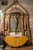 <center>Saint-Genis des Fontaines.</center>Retable du Christ du XIXème représentant le Christ en croix, avec les instruments de la Passion entouré de la lune et du soleil, de St Jean et d'une Vierge dolorosa. En haut, dans l'écusson, les cinq taches symbolisent les cinq plaies du Christ.