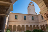 <center>Le cloître de Saint-Genis des Fontaines.</center>Dès le IXe s., une abbaye se caractérise par son plan régulier, rassemblant l’église monastique et les bâtiments (réfectoire, dortoir, salle capitulaire) autour d’un cloître, sorte de jardin entouré d’une galerie. Cloître du latin (claustrum) veut dire clôture, lieu clos, et exprime par là même la vie menée en commun par les moines. Le cloître sert de liaison entre les bâtiments, de promenoir pour les moines, et pour certaines cérémonies, notamment des processions. A l’époque romane, on adopte le principe de galeries composées de colonnes et de chapiteaux sculptés, suivant un riche programme iconographique.
Le cloître de Saint-Genis des Fontaines a été construit au XIIIe s. Sa particularité est d’être construit en marbres polychrome, le blanc de Céret, le rose de Villefranche de Confient et le noir des Corbières Roussillonnaises.