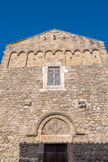 <center>Eglise Romane Saint-André</center>Sur une bonne hauteur, les murs montrent la maçonnerie, caractéristique de l’époque pré-romane : de gros galets de rivière, disposés en arête de poisson, », ou « opus spicatum », avec un abondant mortier de chaux ; aux angles, de gros blocs taillés qui sont souvent des remplois provenant d’édifices plus anciens. Au dessus, un petit appareil constitué des mêmes matériaux mais grossièrement épannelés (XIe), puis pierre taillée en partie supérieure (XIIe). Les deux premières périodes sont sans doute assez proches. La troisième correspond au voûtement de la nef. Cette église pré-romane était moins haute que l’actuelle, et n’avait pas de voûte; son toit était porté par une charpente en bois. C’est sans doute au XIème siècle que l’on a modernisé, surélevé et voûté l’église de Saint-André. La partie haute de la façade correspond par son appareillage soigné au style du XIIe siècle. C’est de la même, époque que date le cloître, avec colonnes et chapiteaux sculptés de marbre blanc, qui a disparu très tôt (au XVème siècle ?) et dont on connaît quelques' éléments dispersés. La façade s'orne de cinq arcs géminés, disposés horizontalement à la partie supérieure de l'édifice., qui sont un décor lombard.