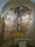 <center>Musée Art Roman.</center>MAÎTRE DE PEDRINYÀ (fin du XIIe)
Abside de Pedrinyà
Fin du XIIe - début du XIIIe. Fresque reportée sur toile. Cette peinture murale a été disposée ici telle quelle a été retirée de son lieu d’origine : l’abside de l’église romane de Pedrinyà (Baix Empordà). Elle est anonyme et il est difficile d’en déterminer la filiation et la chronologie. La voûte est présidée par la Maiestas Domini, l’image du Christ sur un trône, tel que le décrit le livre de l’Apocalypse, entouré des animaux symboliques des quatre évangélistes. En bas, en demi-cercle, sont représentées les scènes successives du mystère de l’Incarnation : l’annonce faite à Marie, la visite à Élisabeth, la naissance de Jésus et l’annonciation aux bergers ; tout porte à croire que le fragment disparu correspondait à l’adoration des Rois mages. Mais ces scènes bibliques sont, non pas séparées les unes des autres, mais plutôt montrées ensemble, comme sur la scène simultanée d’une crèche populaire. Le triomphe de Jésus au ciel de l’abside contraste avec la simplicité des épisodes liés à sa venue sur Terre.