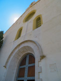 <center>Église Santa Maria de Cadaqués. </center>La façade est couronnée par un clocher à base carrée avec un corps supérieur octogonal et badigeonnée comme la plupart des maisons de la ville.