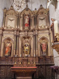 <center> Ille-sur-Têt.</center>L'église Saint-Étienne. Le retable de Saint Boniface fut entièrement construit à la fin du XIXème siècle. Les commanditaires, au premier rang desquels figure l’abbé Bonet (son nom est inscrit sur un cartouche à droite du retable), l’ont voulu en tous points conforme à ces retables plateresques que l’on avait édifiés à la fin du XVIème siècle et la première moitié du XVIIème siècle. D’où ces colonnes cannelées, ces étoiles, ces feuillages ou ces épis utilisés dans la décoration. Le sculpteur Rousseau reçut une somme très importante pour prix de son travail et des matériaux utilisés : l’ensemble, y compris l’autel tombeau, est en bois blanc d’Arkangel, à l’exception d’une prédelle avec quatre panneaux sculptés racontant la vie du saint et son rôle dans l’histoire illoise, qui sont en tilleul. Rousseau acheva son oeuvre en 1896.