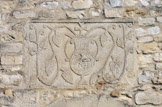<center><center>Vaison-la-Romaine : la chapelle Saint-Quenin</center></center>Le bas-relief qui orne le dessus de la porte représente un vase d'où s'échappent des pampres de vigne et des grappes de raisin, le tout surmonté d’une croix latine gemmée. Ce motif est devenu le blason officiel de la ville de Vaison en 1630 par les consuls de la ville.