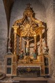 <center>L'abbaye Sainte-Marie-d'Arles-sur-Tech </center>L’absidiole nord-ouest abrite le retable à baldaquin du Christ de la fin du XVIIIe siècle. L'art baroque qui est caractérisé par le mouvement et la surcharge décorative, s'assagit. Il fait place au vide entre les colonnes et met l'accent sur la gloire du couronnement. Le crucifix central est utilisé depuis le XVIIIe siècle pour la procession nocturne du Vendredi saint.