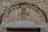 <center>L'abbaye Sainte-Marie-d'Arles-sur-Tech </center>La façade. Le Christ en gloire, assis et bénissant dit Pantocrator. Sur les branches de la croix, dans des médaillons, figurent les symboles des quatre évangélistes : l’aigle pour Saint Jean, le lion pour Saint Marc, le taureau pour Saint Luc et l’ange pour Saint Matthieu. Au-dessous du Christ, le linteau en granit est ornementé de l’Alpha et de l’Oméga. Il pourrait être le seul souvenir de l’édifice du IXe siècle.