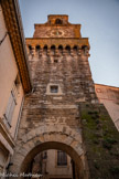 <center>Grignan.</center>Tour de la porte du Tricot de l'enceinte de la ville, ou beffroi. Cette porte fortifiée est l'une des deux portes fortifiées ayant subsisté à Grignan. Elle date du XIIIe siècle et a été surélevée en 1600 afin d'accueillir une cloche et une horloge publique qui lui valent son surnom de beffroi. Le parement de la voûte a été restauré.