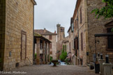 <center>Cordes-sur-ciel. La place de la Bride</center>Les colonnes des halles et le clocher de l'église.