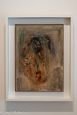 <center>Abbaye de Beaulieu-en-Rouergue  </center>Henri Michaux (Namur, 1899 - Paris, 1984)
Tête tragique.
1954-1955
Huile sur carton.
Michaux peint à l'huile dès 1926. Cependant, il cherche sans cesse à gagner en souplesse et en vitesse d'exécution. S'accommodant mal du temps de séchage de t'huile et de son caractère pâteux, il lui préfère l'encre de Chine, l'aquarelle, la gouache et, plus tard, l'acrylique. Pourtant, l'huile revient régulièrement dans sa production, comme Illustre cette œuvre, surnommée Tête tragique par Geneviève Bonnefoi. S'inscrivant dans la lignée des têtes à l'aquarelle de 1946-48, elle sera suivie de la période mescalinienne.