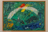 <center>Noé et l’arc-en-ciel</center>1961-1966.
Huile sur toile.
La fin du Déluge et la sortie de l’arche marquent la fin du courroux divin et une nouvelle étape pour l'humanité. Dieu envoie à Noé la vision d’un arc-en-ciel en signe d'Alliance avec le peuple juif. Chagall représente cette apparition dans le ciel comme une courbe blanche, qui contraste avec le reste de la composition, à dominante verte. Noé, figuré allongé en bas à droite , lève les yeux vers cette vision. Un ange au profil barbu, vêtu d'une tunique jaune et arborant une aile rouge, apparaît derrière l’arc- en-ciel. Il annonce à la fois les bonheurs promis par cette alliance, visibles dans la partie supérieure du tableau, mais aussi les malheurs des Juifs, évoqués par les maisons en feu et la foule qui s’enfuit.