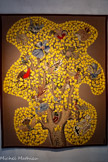 <center>Le musée Dom Robert et de la tapisserie du XXe siècle</center>L’Arbre qui chante.
D'après Dom Robert (1907-1997)
Tapisserie de basse lisse, , laine et coton Tissage atelier Tabard, Aubusson, 1950, ex. 1 Carton de 1950 213 x 176 cm. <br>Avec ce titre très joyeux, Dom Robert propose en 1950 sa première variation du thème de l’arbre aux oiseaux, associé ici à celui de l’automne. La forme très dessinée du contour de l’arbre se détachant sur un fond uni ocre brun rend cette œuvre très originale. Le feuillage d’automne, dans lequel se fondent des oiseaux remplace, avec son motif répété de petites feuilles stylisées, les mille-fleurs de la tradition des verdures. Le traitement très graphique en dents de scie du tronc et des grosses branches ajoute à la modernité de l’œuvre, comme le traitement unique de chaque oiseau. Aussi fantastique que réel (geai, pic épeiche, huppe, pinson, mésange bleue, gelinotte des bois, bécasse, étourneau ...), chacun d’eux possède une attitude différente et semble « dialoguer » avec son voisin.
L’ensemble évoque un célèbre chant polyphonique de la Renaissance, Le chant des oiseaux de Clément Janequin, plutôt que le grégorien monastique.