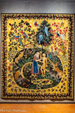 <center>Le musée Dom Robert et de la tapisserie du XXe siècle</center>La création de l’homme.
D’après DOM ROBERT (1907-1997)
Tapisserie de basse lisse. Laine et coton.
Atelier de La Beauze, Aubusson, 2004 1 Carton de 1946, 400 x 540 cm <br> Premier élément de la suite (jamais aboutie) destinée au chœur de l’abbatiale d’En Calcat, le carton a été tissé en exemplaire unique en 1946 chez Tabard à Aubusson. La tapisserie a été acquise par l’État français, puis offerte en 1954 par le Président Coty à la reine des Pays-Bas. L’exemplaire ; présenté a été tissé en 2004 pour la collection du musée. Des prélèvements de laines réalisés sur l’envers du premier exemplaire ont permis de recréer les couleurs choisies par Dom Robert. Celui-ci avait notamment repris en partie la palette utilisée pour L’Automne datant de 1943. Pour sa composition, Dom Robert s’inspire des tapisseries anciennes dont il a retenu la bordure à entrelacs. La scène se déroule au milieu d’une nature à la flore et à la faune fort riches, dans un style encore marqué par l’enluminure. Dom Robert instille la symbolique traditionnelle du Paradis terrestre. La forme ovoïde renvoie à la terre primordiale d’où surgit l’arbre de vie. Sous les pieds du Dieu créateur, sourd la rivière de jouvence dont la forme serpentine suggère aussi la chute à venir. Le Père créateur, en ; pantoufles et tunique de brocard, façonne dans l’argile le premier homme, Adam, dont le nom signifie littéralement le glaiseux. Il porte le tablier bleu des moines d’En Calcat au travail.