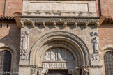 <center>Basilique Saint-Sernin de Toulouse</center>Deux personnages placés de chaque côté du tympan ont des dimensions dépassant celle du Christ.La corniche au-dessus du tympan de la porte est composée de huit modillons sculptés. De gauche à droite : Personnage en position d'atlante s'appuyant sur une tête de lion ; Cep de vigne et grappes de raisin ; Fauve posant une patte sur sa tête ; Tête d'un animal avalant les pattes d'un fauve ; Sol émergeant de son voile ; Lune dévoilée ; Tête caprine dont il manque une partie ;a patte.