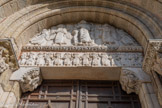 <center>Basilique Saint-Sernin de Toulouse</center>Délimité par son arc plein-cintre, le tympan représente l’Ascension du Christ, soutenu par six anges. Le linteau nous montre les douze apôtres, y compris saint Pierre et saint Paul qui sont reconnaissables par leurs caractéristiques physiques et un attribut habituels. Les apôtres ont leurs têtes tournées vers le haut, fixant le Christ comme fascinés par l’évènement miraculeux. Le même espace contient aussi, latéralement, deux personnages ailés et coiffés d’un bonnet phrygien, présentant des manuscrits (anges avec les Écritures?). Les consoles qui soutiennent le linteau sont décorées, à gauche par le roi David avec son instrument de musique, et à droite par deux personnages, coiffés comme ceux du linteau par des bonnets phrygiens