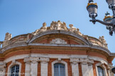<center>Le Capitole.</center>Aile sud. Sur le fronton de droite, la Tragédie et la Comédie encadrent les attributs de la musique. Il était donc logique que le Théâtre du Capitole, fort de ses plus de 1100 places et inauguré en octobre 1818 à l’emplacement du théâtre érigé par les Capitouls en 1736, prenne place dans cette partie artistique du Capitole.