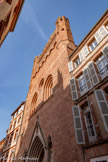 <center>L'église Notre Dame-du-Taur </center>La façade occidentale de l’église, dans laquelle s'ouvre le portail, est enchâssée dans l'alignement des maisons. Elle se présente comme un grand mur de briques, monumental clocher-mur. S'il n’est pas le plus ancien de la région – le clocher-mur de l’église Saint-Étienne, à Montaudran, date du XIIe siècle –, il est l’un des plus élevés, puisqu’il culmine à 42 mètres.