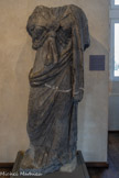 <center>Musée Saint-Raymond</center>Isis.
Marbre noir de Saint-Béat (Haute-Garonne)
IIIe-IVe siècle. <br>
Cette déesse égyptienne a acquis un aspect grec depuis la conquête de l'Égypte par Alexandre le Grand. Elle représente la fertilité, les activités humaines mais aussi la justice et les préceptes moraux. L'Égypte et sa culture étaient à la mode dans l'Empire romain. La figure d'Isis est souvent présente sur des objets du quotidien mais à Chiragan, elle apparaît de façon bien plus spectaculaire.
Le marbre noir traduit la couleur de la déesse. Tête, bras et pieds étaient sculptés dans un marbre de couleur différente, probablement blanc. Entre les seins, on distingue le nœud dit isiaque qui rappelait le hiéroglyphe ânkh (symbole de la vie).