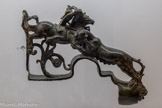 <center>Musée Saint-Raymond</center>Cette grande pièce en bronze  représente une chasse au fauve. Elle décorait peut-être un meuble ou la caisse d’un char.
Le thème de la chasse, à cheval ou à pied, était souvent employé comme élément de décor dans les demeures des élites grecques puis romaines.
En plus de la chasse, les chevaux étaient utilisés pour le transport des marchandises et des personnes, la guerre et les courses de chars dans les cirques (5-6).
Les équidés (chevaux, ânes, mules) faisaient donc partie de la vie quotidienne des Romains.