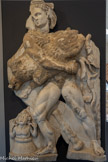 <center>Musée Saint-Raymond</center>Hercule et le sanglier d'Érymante. Quatrième des douze travaux. Grèce, Péloponnèse, Erymante.
Un gigantesque sanglier vivait sur la montagne d'Érymante et dévastait toute la région. Eurysthée fit appel à son cousin Hercule d'Héraclès grec) pour attraper vivante la redoutable bête.
Le héros profita de l'hiver et de la neige pour courser l'animal jusqu'à l'épuisement.
Sur ce relief, Hercule tient vigoureusement contre sa poitrine le sanglier qu'il ramène à Eurysthée. Ce dernier, terrorisé à la vue de l'animal monstrueux, s'est réfugié dans une jarre à grain (dolium), à demi-enterrée dans le sol. Il lève les mains pour implorer la protection des dieux.
Le sculpteur l'a représenté tout petit pour montrer sa frayeur, le ridiculiser mais aussi parce qu'il s'agit d’un personnage secondaire.