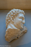 <center>Musée Saint-Raymond</center>Hercule et le lion de Némée
Premier des douze travaux. Grèce, Péloponnèse, Némée.
Aucune arme ne pouvait pénétrer la peau de ce lion. Hercule étouffa le félin et déchira sa fourrure avec les propres griffes du lion. Cette peau, la léontê, devint ensuite la cuirasse qui le protégeait. Le héros est imberbe car il est jeune et ne porte pas encore la léonté. C’est cet indice qui permet de le rattacher à ce premier travail. Les arcades sourcilières tombantes sont caractéristiques du style des Travaux d’Hercule.