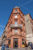 <center>La rue Croix-Baragnon.</center>Cet immeuble construit entre 1830 et 1860, est situé à l'angle des rues Boulbonne et Croix-Baragnon. Il possède une travée d'angle en pan coupé ouvrant sur la place Saint-Étienne. Toutes ses élévations sont parées d'ornements en terre cuite comme les faux garde-corps, les motifs de coquilles et de fleurons formant la frise supérieure ainsi que les antéfixes bordant le toit. Toutefois, l'angle coupé concentre les pièces de céramique les plus importantes. Couronnant la porte, le fronton porte une pièce de cuir découpé orné d'un fil à plomb, d'un marteau et d'une gradine. Deux cornes d'abondance complètent l'ensemble. Au dessus, la fenêtre de l'entresol est encadrée par des figures en pied. D'un côté, Hermès, dieu du Commerce tient une bourse et un caducée. A ses pieds, se distinguent une ancre marine et un ballot. De l'autre côté, la muse de l'industrie maintient une masse posée sur une enclume posée près d'une roue à dents. Tous ces éléments évoquent un ensemble de métiers variés liés au commerce, à l'industrie ou à la construction.
