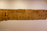 <center>Musée des Abattoirs</center>Tissu de cérémonie pour rois et reines (Ntshak) Vers 1920. Réalisé en République démocratique du Congo. Le vêtement brodé présenté ici est un pagne par l'une des tribus Kuba, celle des Shoowa.
L’art des Shoowa présente un sens du dessin extrêmement aigu et singulier. La géométrisation de ses lignes se décline de manière complexe et variée (nombres, modules élémentaires, rythme…) et jouent sur des phénomènes optiques. Les teintes sont éclaircies pour les arts royaux car le blanc est la couleur de la noblesse.
Les vêtements royaux sont réservés aux danses rituelles et religieuses. Ils sont enroulés à la taille des rois et reines. Ces très grands assemblages de fragments de tissu en raphia sont cousus dans le sens de la longueur ou en quadrilatères de petites dimensions. Comme ils servent longtemps, des reprises d’accrocs apparaissent. Dans cette société où le dessin envahit tout, l’exécution est rapide et en perpétuelle recréation.
“Le sens du dessin est celui de son tracé successif.” (Georges Meurant, Dessin Shoowa : textiles africains du Royaume Kuba, 1986). Daniel Cordier, grande figure de la Résistance française, marchand d’art et historien, a fait une donation importante de sa collection au Centre Pompidou dont une partie est déposée aux Abattoirs.
Cette donation comporte des objets qu’il considère comme « la structure originelle » de son goût pour l’art.