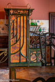 <center>Le château Laurens</center>Armoire asymétrique, signée Cauvy, c'est-à-dire à un grand vantail à gauche et, à droite, une partie à hauteur d'appui, fermant à deux vantaux, surmontée par quatre étagères ; à gauche, un tabouret à deux pieds appuyé contre la partie à grand vantail. Les portes sont agrémentées de cuir repoussé à motifs végétaux, dans le style Art Nouveau. A droite, devant cette armoire, un fauteuil en bois sculpté, à dossier ajouré. L'assise et une partie du dossier sont argrémentés de cuir repoussé. Ornementation dans le style Art Nouveau.