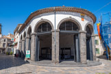 <center>Vias</center>Place du 14 juillet. Les halles. Il est probable qu'il y ait eu au même emplacement un marché couvert dès l'époque médiévale. La halle a été reconstruite entre 1828 et 1830 à l'initiative du maire, François Rascas de Palignan. La date est inscrite sur la pierre formant clé de voute d’un des arcs. Les huit ouvertures sont constituées de piliers qui portent des arcs de plein cintre. Le blason de la ville est placé sur le mur au sud. Orné de fleurs de lys bleues, il représente le symbole de l’autorité royale sur le village. C'est lors de cette campagne de travaux qu'a été rajoutée la partie arrondie qui ne figure pas sur le cadastre napoléonien, selon le plan dressé par un architecte agathois nommé Nègre.
C'est en 1996, lors de la réfection de la place du marché, que fut apposée la plaque le recanto de la blaguetta, en guise de clin d'œil aux aînés qui aiment tant s'y retrouver pour y commenter l'actualité aussi bien mondiale que locale. En 2017, la dalle avec un carrelage en pierre basaltique locale a été installée. Un ceinturage totalement reconstruits. Des points d’eau et des arrivées électriques ont été installés au sol. Une nouvelle façade à la chaux a été mise en œuvre.