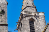 <center>Vias : l'église Saint-Jean-Baptiste </center>La particularité de cette église est la coursière en encorbellement autour du clocher, qui conduit à une petite guérite accessible par un escalier à vis. Cette coursière permettait de renseigner les gens repliés dans l’église. Avec cette tour-clocher particulière, l’église faisait partie des principaux organes défensifs de la ville. Située dans le prolongement des remparts circulaires de la ville, elle présente de nombreuses fortifications