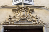 <center>Rue des lanciers.</center>Ancienne caisse d'épargne du XIXe. Ici le blason est  surmonté d'une couronne comtale et les B sont remplacés par des C, reprenant peut-être l'initiale d'une grande famille de la commune ou encore du fait de l'appellation de celle-ci « Cité des Comtes de Provence ».