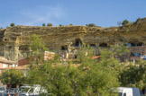 <center></center><center>Les maisons troglodytes de Saint-Chamas. </center> Vue du port du Pertuis, côté Ouest, la falaise aux couleurs changeantes, passant du gris au jaune, présente des ouvertures à une belle hauteur, en à pic de la rue du Baou.
Ces ouvertures sont autant de fenêtres, de baies vitrées ou non, des habitats troglodytiques aménagés dans les grottes dont l’entrée principale se situe, côté Est, dans le village, rue des Pénitents mais ici, nous disons montée des Pénitents.
Ces « baumes » ne sont pas toutes naturelles.
Elles ont été creusées pour servir de remises, de bergeries, de champignonnières et aussi de moulin à huile.
La plus ancienne daterait des années 1600.
Le long de la rue du Baou, des grottes sont visibles à l’état brut. Il arrive que des blocs de safre se décrochent et la prudence est de mise.
En 1615 seulement deux grottes naturelles étaient habitées.C'est seulement après que le seigneur de Saint Aman ai cédé ses droits de propriété au conseil de communauté, que l'autorisation de creuser des grottes est officielle.
Les travaux pour vivre dans une grotte sont de deux ordres : creuser pour élargir et approfondir, en tenant compte des voisins et des risques d’éboulement et puis agencer en intégrant tout le confort : eau, électricité…et les pièces à vivre.
Aucun problème pour l’isolation, elle est naturelle aussi bien phonique que climatique et la grotte garde une température quasi constante été comme hiver.
Les murs sont à 19° tout le temps, et l'air ambiant subit des variations allant de 18 à 23°, très naturellement.
Ces habitats sont, écologiquement et économiquement parlant, très performants.