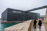 <center></center><center>Journée inaugurale</center> L’architecte a imaginé le futur musée dans un matériau inspiré par « le paysage minéral de Marseille et les pierres du Fort Saint-Jean » : le béton. Pas un béton ordinaire, un béton « exceptionnel, à la pointe des dernières recherches scientifiques » qui lui permet de faire… de la dentelle ! Sur le môle va donc s’élever un cube minéral bordé de douves, enserré par une résille de béton fibré et des façades brise-vent qui laisseront passer la lumière, l’air et les odeurs d’iode.