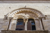 <center></center><center>Le Musée d'Art Sacré du Gard. </center> La baie centrale située à l'étage de la façade sur la rue Saint-Jacques a gardé son décor roman. Une large archivolte ornée de motifs en croisillon protège une frise de lourdes perles en forme d'olives qui s'appuie sur des colonnes à chapiteaux. A l'intérieur, sous un tympan autrefois peint et décoré d'un bacino hispano-moresque (coupelle aux motifs végétaux de lustre métallique), deux baies géminées cintrées, dont les gorges sont remplies de modillons profilés à l'antique irrégulièrement posés, sont réunies par une colonne cannelée surmontée d'un chapiteau.
Il faudrait situer la réalisation des chapiteaux de la Maison des Chevaliers, et donc de la façade, au cours de la dernière décennie du XIIe siècle. Le reste du décor confirme l'influence aixoise qui s'est exercée dans la Basse Vallée du Rhône à cette époque.