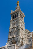 <center>Notre-Dame de la Garde</center>Le clocher avec la Vierge. La reconstruction du clocher en 1843 lui permet de recevoir non plus une cloche mais un bourdon commandé à un fondeur lyonnais Gédéon Morel et acheté grâce à une souscription. Le bourdon fondu le 11 février 1845, arrive à Marseille le 19 septembre 1845. Le bourdon est mis en place le mercredi 15 octobre. La consécration du sanctuaire est donnée le samedi 4 juin 1864 par le cardinal Villecourt.