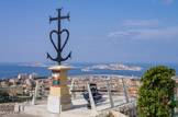 <center>Vue de Notre-Dame de la Garde.</center>Cénotaphe pour les disparus en mer. La croix des gardians symbolise les trois vertus théologales : La Croix pour la Foi. L'Ancre pour l'Espérance. Le Cœur pour la Charité. Les 3 extrémités de la Croix sont terminées par des tridents représentant les gardians et l'âme camarguaise.