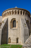 <center>Saint Guilhem le Désert. </center> L'abside est contrebutée par de gros contreforts qui se terminent en glacis. Ils furent peut-être construits par les Mauristes. Trois grandes baies apportent la lumière dans l'abside. Elles sont encadrées de colonnettes en marbre d'origine antique. Les chapiteaux à motifs végétaux stylisés surmontent ces colonnettes. À la base, se trouvent trois petites baies cintrées destinées à éclairer la crypte.