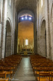 <center>Saint Guilhem le Désert. </center> La nef surprend par sa grande hauteur (18 mètres de haut) pour une largeur de seulement 6 mètres. Les murs et les piliers de l'église sont appareillés en pierre froide alors que la voûte en berceau est construite en tuf. Le premier niveau d'élévation de la nef est occupé par des arcades qui ouvrent sur les bas-côtés. Le deuxième niveau comporte des baies en plein cintre qui apportent ainsi un éclairage direct au haut-vaisseau.