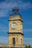 <center>La Tour de l'horloge</center>Le pavillon, bâti sur pilotis entre 1772 et 1775, est surmonté d'une tour carrée de 24m, elle-même ornée d'une horloge avec cadran horaire.
La terrasse de la tour servait aux guetteurs en charge de la surveillance de l'Arsenal. Au-dessus de la terrasse, nichée au sommet de la tour, une cloche était enserrée dans un campanile en fer forgé.
À l'époque, elle annonçait les heures de début et de fin de travail. Elle sonna la mobilisation de 1914 et fut remplacée par une sirène en 1918.
Depuis 1929, la cloche est posée sur un socle devant le bâtiment de l'Horloge. Une fausse cloche en bois est suspendue dans le campanile depuis 1954.