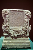 <center> </center><center>Autel d'un Vétéran. IIe siècle apr.J.-C. Marbre</center>Bien que les têtes de bélier des angles supérieurs suggèrent une fonction  funéraire pour cet autel, son inscription indique qu il s'agit d'un monument votif, consacré à Esculape, le dieu romain de la santé. Les trous au sommet servaient fixer l'offrande, probablement une statuette. L'autel a été dédié par Marcus Aurélius Venestus qui s'était retiré de la carrière militaire, après au moins 16 ans de service comme vétéran de la neuvième cohorte prétorienne. Il a dû recevoir la somme de 20 000 sesterces, un domaine à la campagne et un diplôme honorifique. Au IIe siècle apr. J.-C, les 5 000 gardes prétoriens répartis en une dizaine de cohortes constituaient une élite jouissant de nombreux privilèges, notamment une paie plus élevée de moitié que celles des autres légionnaires.