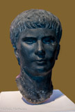 <center>Portrait d'Agrippa Postumus Vers 4 apr. J.-C. Découvert à Alexandrie (Egypte) (?) Basanite</center><center>Portrait d'Agrippa Postumus Vers 4 apr. J.-C. Découvert à Alexandrie (Egypte) (?) Basanite</center>Agrippa Postumus (12 av. J.-C. - 14 apr. J.-C.) était le petit-fils de l'empereur Auguste. Après la mort prématurée de ses deux frères, il fut le dernier descendant direct d'Auguste à pouvoir devenir empereur. Mais, pour des raisons qui demeurent peu claires, le jeune prince tomba en disgrâce et fut exilé en 7 apr. J.-C. sur une petite île de la côte italienne où il fut mis à mort sur l'ordre de Tibère, après le décès d'Auguste. Dans ce portrait, Agrippa Postumus montre une contenance assurée, comme son père Agrippa. Le front bas et des sourcils marqués lui confèrent une expression déterminée, voire butée.