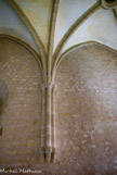 <center>Abbaye de Noirlac. </center> Le réfectoire. Les huit voûtes ogivales ont leurs arcs qui retombent en palmiers sur trois colonnes.