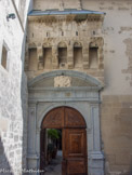<center></center><center>Romans-sur-Isère. </center> Porte de l'hôtel de Clérieu. Pour le protéger, une porte fortifiée est construite vers 1450 (très belle tête de lion, à gauche du mâchicoulis).