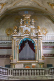 <center>Sanctuaire de Notre Dame de la Côte.</center>La porte principale est surmontée par la tribune de l'orgue. L'instrument a été réalisé en 1839 par l'organier Antonio Buzzoni. Il a été restauré en 1986, et aussi en 1995, comme d'ailleurs son précieux buffet en bois, qui date probablement de la moitié du XVIII siècle : ainsi nous pouvons admirer son élégant jeu de couleurs et son dessin d'ornement, qui est composé d'un vol d'anges, qui entourent la couronne avec l'écusson et la lettre 