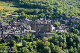 <center>Conques</center>Vue générale depuis le site du Bancarel. Entre 864 et 875, événement capital, un moine de Conques, Ariviscus (ou Aronside), parvient à dérober les reliques de sainte Foy dans une église abbatiale située aux environs d’Agen, où sainte Foy avait subi le martyre à l'âge de douze ans en 303. Cette pratique est très courante au Moyen Âge ; elle est pudiquement appelée « translation furtive ». Ce vol pieux aurait immédiatement déclenché des miracles, ce qui provoqua la venue de nombreux pèlerins. Pendant la même période, un tombeau attribué à l'apôtre saint Jacques est découvert à Compostelle. Vers 955-960, le comte de Rouergue Raymond Ier de Toulouse est l'un des premiers pèlerins qui se rendent en Galice pour vénérer l'apôtre. Trente ans plus tard, son fils Raimond a un enfant et est vainqueur des musulmans dans les environs de Barcelone ; en signe de reconnaissance, il fait cadeau à Conques d'une magnifique prise de guerre, une selle garnie de parements d'argent ciselé, avec lesquels les moines fabriquent une grande croix qui devient le symbole des chrétiens.