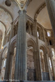 <center>L'église abbatiale Sainte-Foy</center>Les grilles obturant les entrecolonnements de l'abside sont l'une des plus remarquables œuvres d'art de ferronnerie conservées de la période médiévale50. Elles sont constituées d'un réseau de brindilles (qui tiennent le rôle des poteaux de bois) qui déterminent trois types de tracés : quatre volutes reliées par un losange central, quatre volutes soudées par des embrasses et un arbre stylisé à quatre branches. Les grilles sont couronnées de pointes, de dards et de tête de dragons.