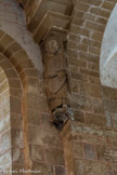 <center>L'église abbatiale Sainte-Foy</center>De l'autre côté est représenté Jean-Baptiste le bras droit levé vers le ciel ; il tient un livre ouvert : 