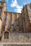 <center>L'église abbatiale Sainte-Foy</center>Façade sud. Extérieurement, la nef ne reflète pas l'étagement intérieur, les tribunes ayant la même largeur que les collatéraux. On obtient ainsi un mur presque droit, sans la cassure fréquente entre le niveau des collatéraux et celui du vaisseau central. Deux étages de fenêtres alignées alternent avec les contreforts, donnant une forte impression de verticalité.