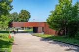 <center>Le musée Soulages.</center>Le musée Soulages a été conçu par Ramén Vilalta, Carme Pigem, Rafael Aranda et Gilles Trégouët regroupés sous le nom RCR arquitectes (Olot - Espagne), associés au cabinet Roques et Passelac (Narbonne). Chacun de ses espaces a été pensé pour accueillir un des aspects particuliers de la collection. Les passages réguliers de l'ombre à la lumière et les élévations rythmées entrent en résonance avec l’œuvre de l’artiste. Sensibles au lieu et au paysage, les architectes ont choisi des matériaux simples : le béton, le verre et surtout, l’acier Corten dont la palette chromatique rappelle les premières peintures sur papier de Soulages, les brous de noix, ainsi que les plaques de cuivre qui ont servi de matrice aux eaux-fortes.