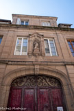 <center>La rue de Bonald</center>L'ancien pavillon d’entrée du grand séminaire a été construit en 1902, comme l'indique la date portée sur la clé d'arc de la porte cochère. Il prend la place de l'entrée du couvent des Annonciades qui s’élevait à cet emplacement jusqu’en 1824 L'immeuble d’inspiration classique s'organise autour d’un passage couvert central. Dans l'élévation sur rue, la porte cochère prend place au milieu d'un avant-corps très légèrement saillant de trois travées et trois niveaux, singularisé du reste de la façade par son parement en pierre de taille, traité en table continue au rez-de-chaussée et rythmé de pilastres. La porte cochère est couverte d’un arc en anse de panier au délardement concave. Le claveau central de l’arc présente les armes de l’évêque de Rodez Louis-Eugène Franqueville et porte la date de 1902. La porte cochère est entourée de deux baies couvertes en plein-cintre. Le premier étage niveau est percé de baies rectangulaires entourant une niche architecturée qui accueille une Vierge à l'Enfant, dite « Vierge des Embergues », datant du 14e siècle. Le chambranle de la niche se compose de deux pilastres à chapiteaux corinthiens et porté par des corbeaux sculptés. La niche est sommée d’une corniche en forme de mitre.